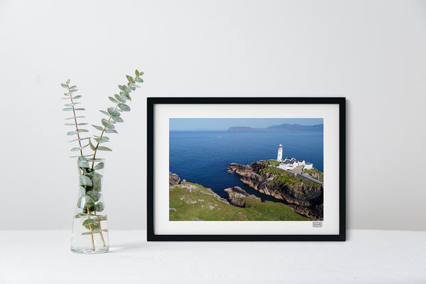 Fanad Lighthouse aerial photograph in a black frame showing Donegal coastline under a clear blue sky.