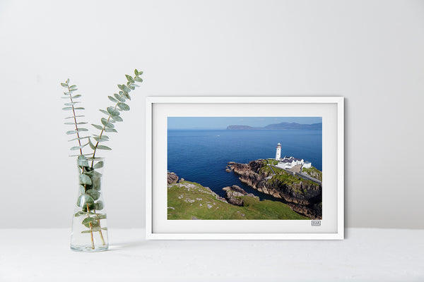 Fanad Lighthouse aerial photograph in a white frame showing Donegal coastline under a clear blue sky.